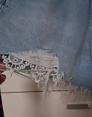 Pantaloncini denim strappati con inserto in pizzo.