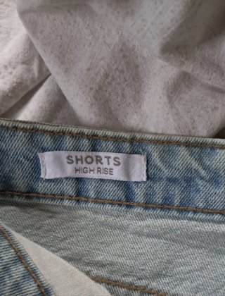 Pantaloncini denim strappati con inserto in pizzo.