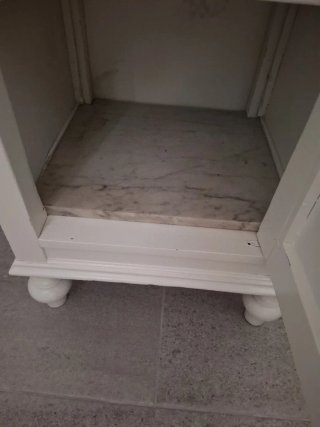 Mesita de noche blanca de madera.