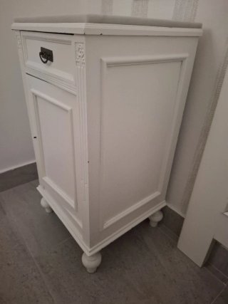 Mesita de noche blanca de madera.