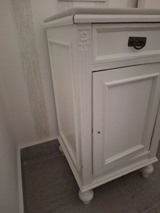 Mesita de noche blanca de madera.