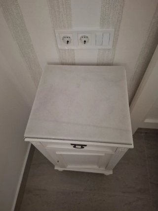 Mesita de noche blanca de madera.