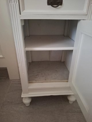 Mesita de noche blanca de madera.