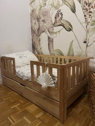 Cama infantil de madera con barrera.