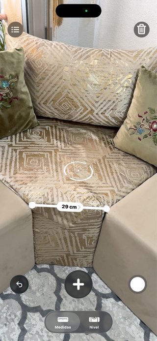 Sofá árabe beige con mesa auxiliar y cortina y