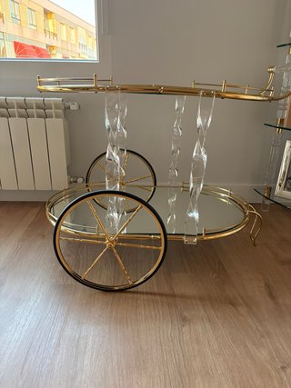Mesa de cristal con camarera dorada.