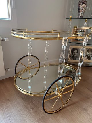 Mesa de cristal con camarera dorada.