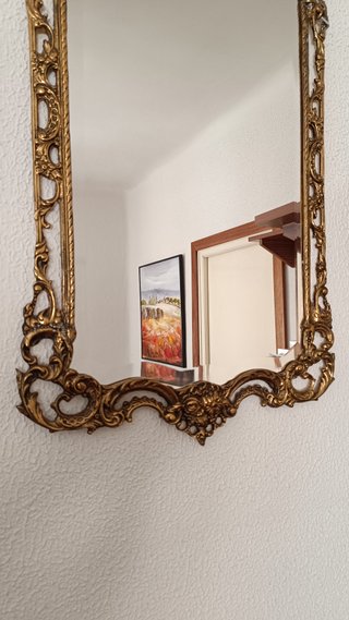 Espejo de bronce con marco ornamentado
