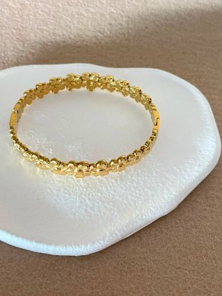 Pulsera dorada con diseño de flores