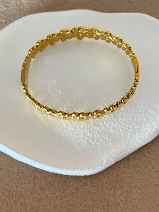 Pulsera dorada con diseño de flores