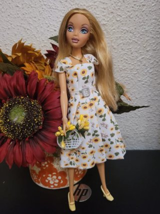 Muñeca barbie con vestido floral y cesta