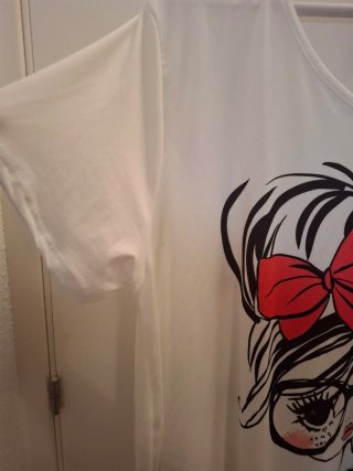 Camiseta blanca con muñeca y lazo rojo