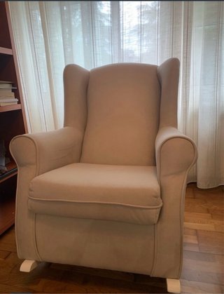 Butaca mecedora de tela beige/gris.