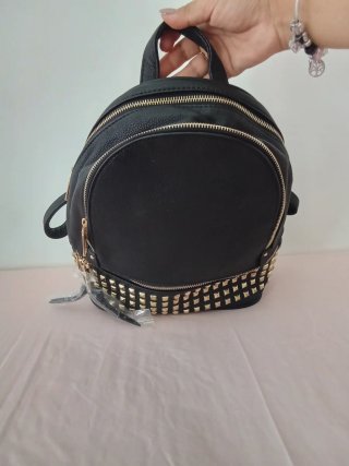 Mochila negra con tachuelas doradas