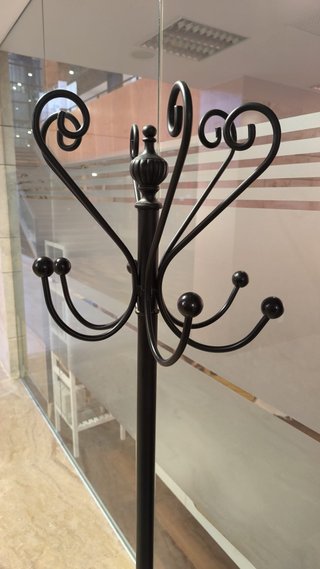 Perchero de pie negro con diseño curvo
