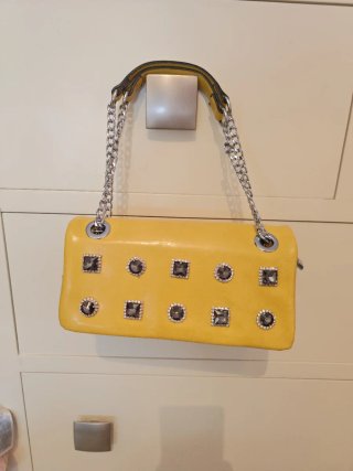 Bolso amarillo con cadena plateada