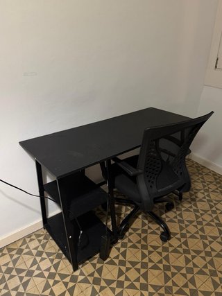 Escritorio negro con estanterías de metal.