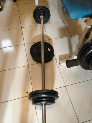 Banco de pesas con discos y mancuernas