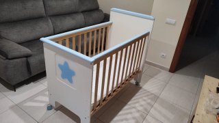Cuna de madera con barandillas y estrella