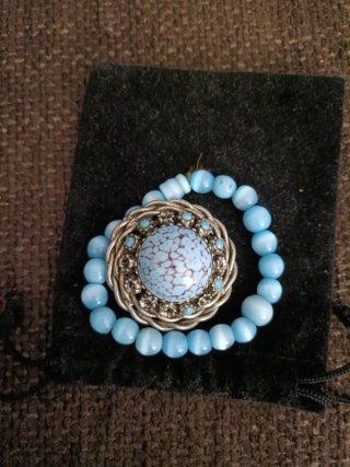 Broche plateado con detalles azules
