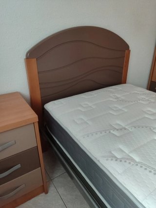 Cama individual, mesita y colchón.