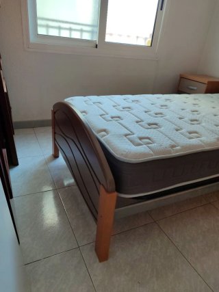 Cama individual, mesita y colchón.
