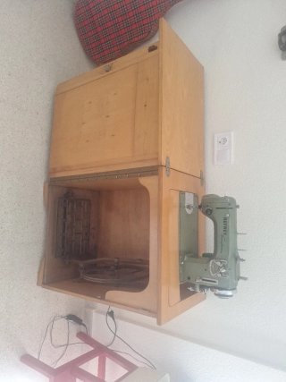 Máquina de coser antigua con motor y mueble