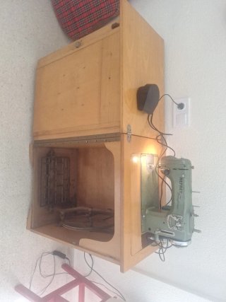 Máquina de coser antigua con motor y mueble