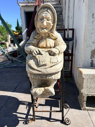 Estatua de piedra de anciana sentada