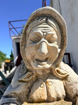 Estatua de piedra de anciana sentada