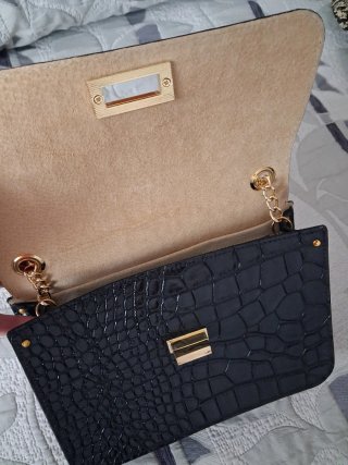 Bolso de mano V&L negro con cadena dorada.