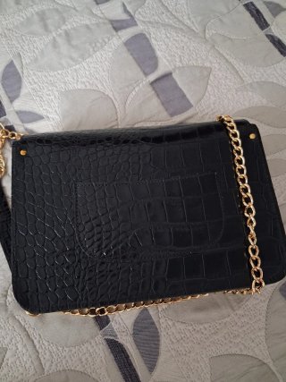 Bolso de mano V&L negro con cadena dorada.
