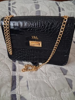 Bolso de mano V&L negro con cadena dorada.