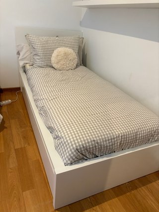 Cama individual blanca con cabecero y colchon.