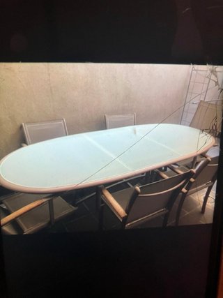 Mesa de cristal ovalada con sillas