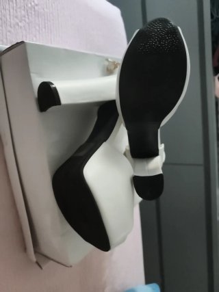 Zapatos de tacón blancos con lazo y piedra.
