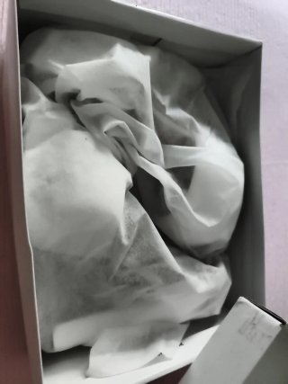 Zapatos de tacón blancos con lazo y piedra.