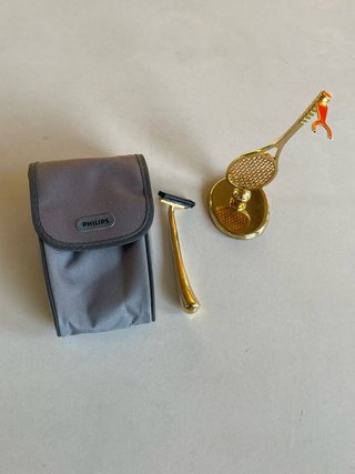 Maquinilla de afeitar dorada con soporte