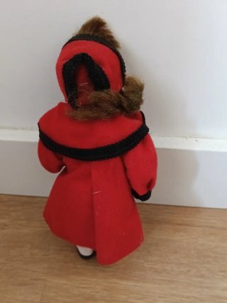 Muñeca de porcelana con abrigo rojo