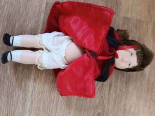 Muñeca de porcelana con abrigo rojo