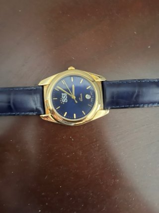 Reloj clásico dorado con correa azul