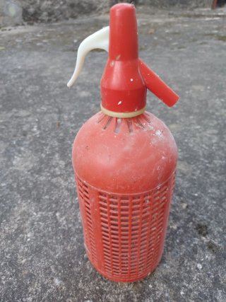 Sifón de cristal, cubierto de plástico rojo