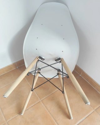 Silla estilo Eames blanca con patas de madera