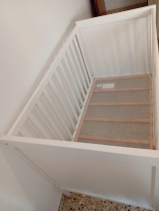 Cuna de bebé blanca con textiles