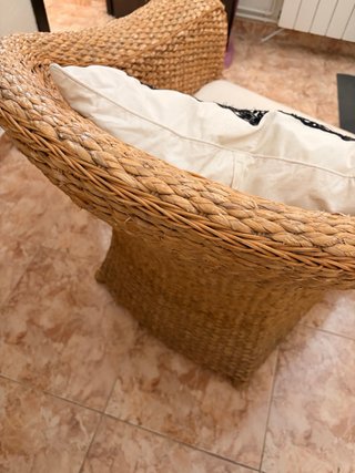 Sillón de mimbre con cojín blanco para habitación