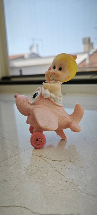 Statuetta bimba in resina con aeroplano