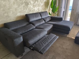 Divano angolare, pouf e tappeto grigio