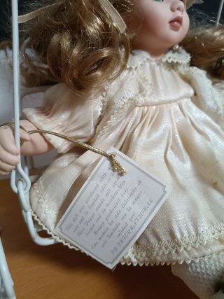 Muñeca de porcelana con columpio