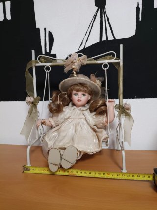 Muñeca de porcelana con columpio