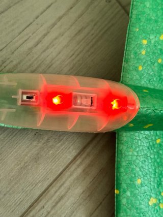 Avión de juguete verde con luces. Planeador